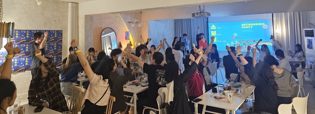 겟백 네트워킹 파티에서 참여자들이 손을 든 현장 사진